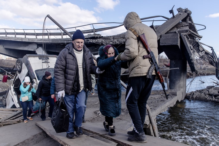 Residents of Irpin and Bucha flee via a destroyed bridge on Thursday, March 10 in Irpin, Ukraine.