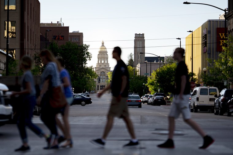 Pedestrians cross the street near the Wyoming State Capitol in downtown Cheyenne, Wyoming on June 19, 2019.