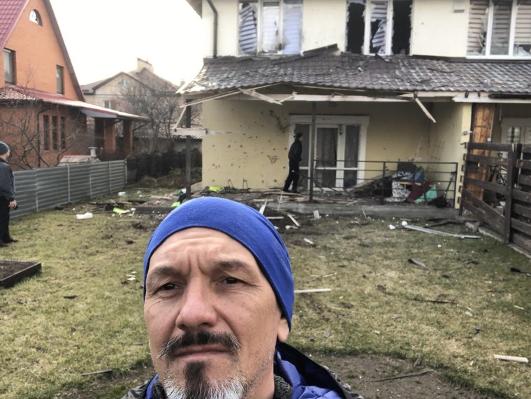 Roman Vlasenko in front of his family home in Vorzel after it was bombed.