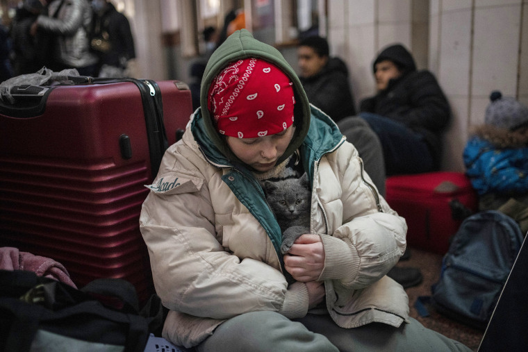 Image: A  child holds her cat in her coat inside the railway station in Lviv, west Ukraine on Feb. 28, 2022.