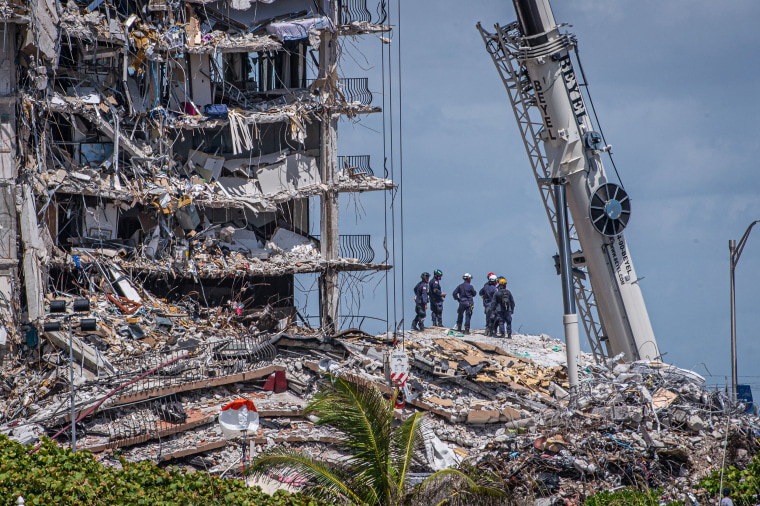 Members of a search and rescue team look for survivors in the partially-collapsed 12-story Champlain Towers South condo on June 27, 2021 in Surfside, Fla.