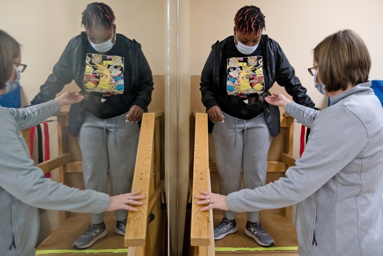 Tionna Hairston works on climbing up and down steps at her physical therapy appointment.