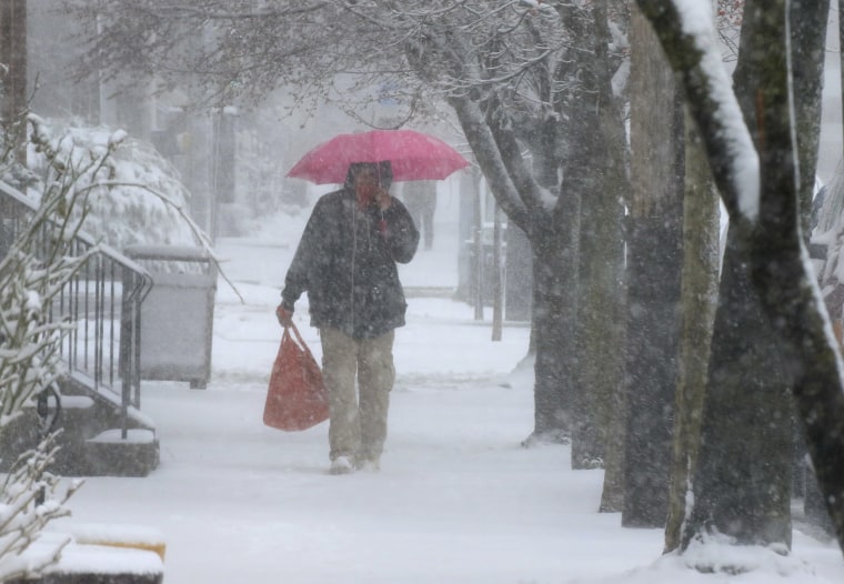 A man walks through Lancaster City, Pa., with his shopping bag during a snowstorm Saturday, March 12, 2022.
