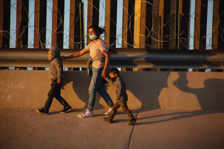A mother and her two children walk to one side of the United States wall after crossing the Rio Grande, the natural border between Mexico and the United States in Ciudad Juarez, Chihuahua, Mexico on May 11, 2021.