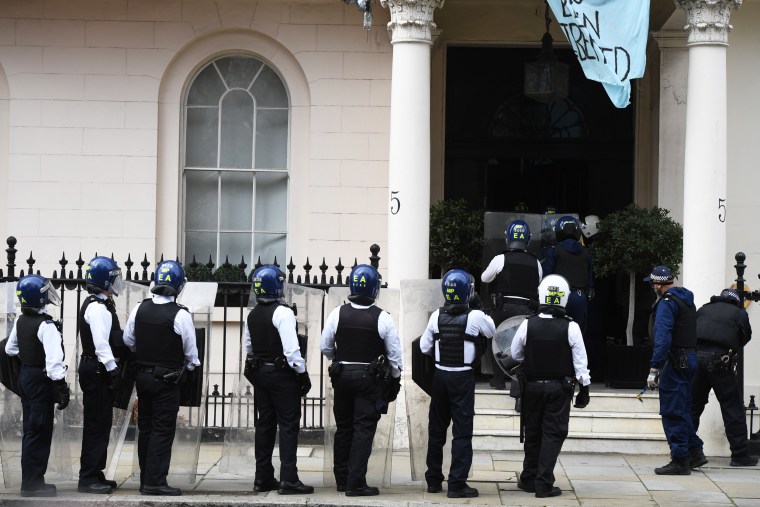 Police officers in riot gear arrive as protesters occupy a building reported to belong to Russian oligarch Oleg Deripaska on March 14, 2022, in London.