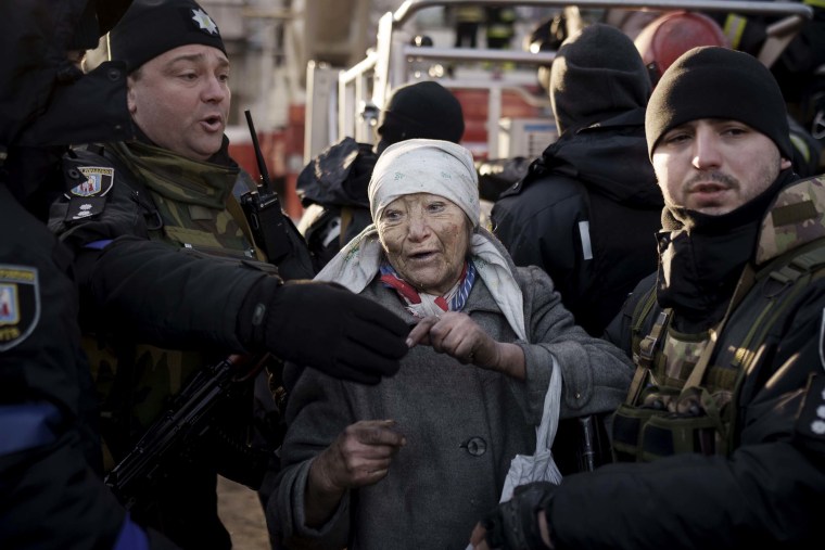 An elderly woman is helped by policemen after she was rescued by firefighters from inside her apartment after bombing in Kyiv, Ukraine on Tuesday, March 15.