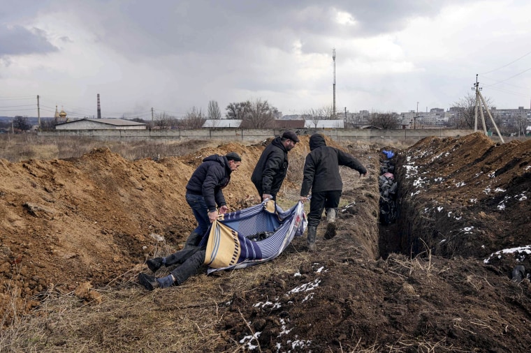 Bodies are put into a mass grave on the outskirts of Mariupol last week. Residents cannot hold funerals because of heavy shelling.