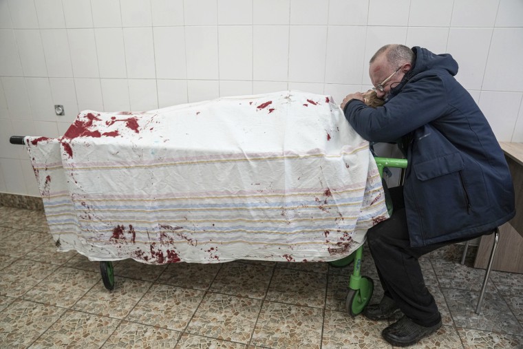 Iliya's father Serhii weeps with his son's lifeless body in a hospital in Mariupol.