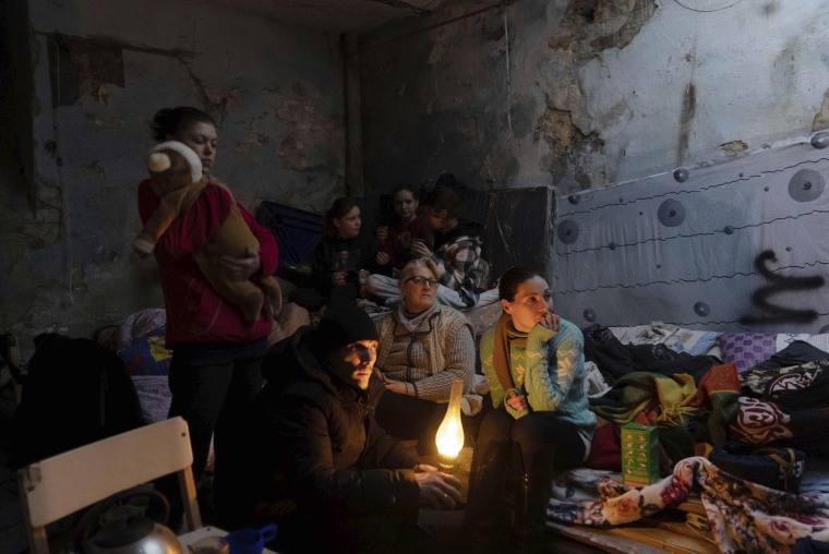People gather in a bomb shelter.  