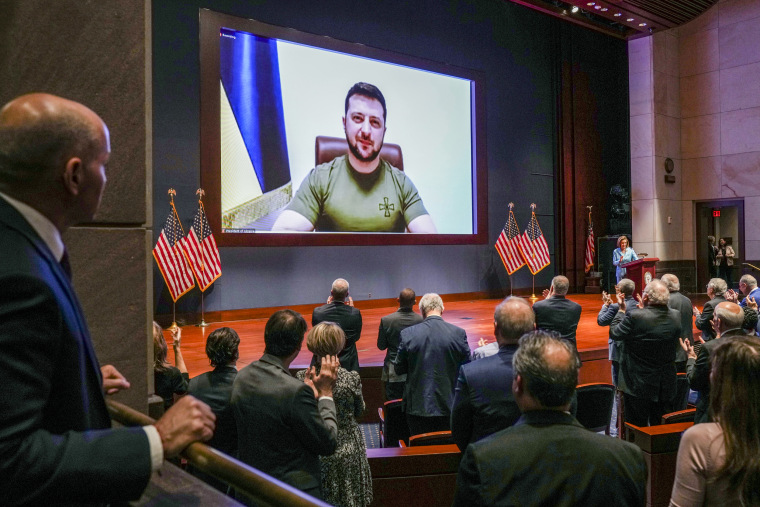 Members of Congress give Ukraine President Volodymyr Zelenskyy a standing ovation before he speaks in a virtual address to Congress in the U.S. Capitol Visitors Center Congressional Auditorium on March 16, 2022.