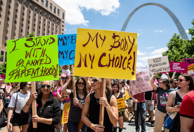 Abortion rights supporters hold signs as they rally near the Gateway Arch in St. Louis, Mo., on May 30, 2019.