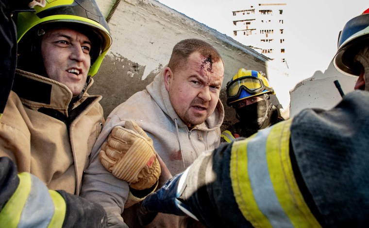 Rescuers evacuate a man from under the rubble of damage by shelling of the National Academy of State Administration building in Kharkiv, Ukraine, Friday, March 18.