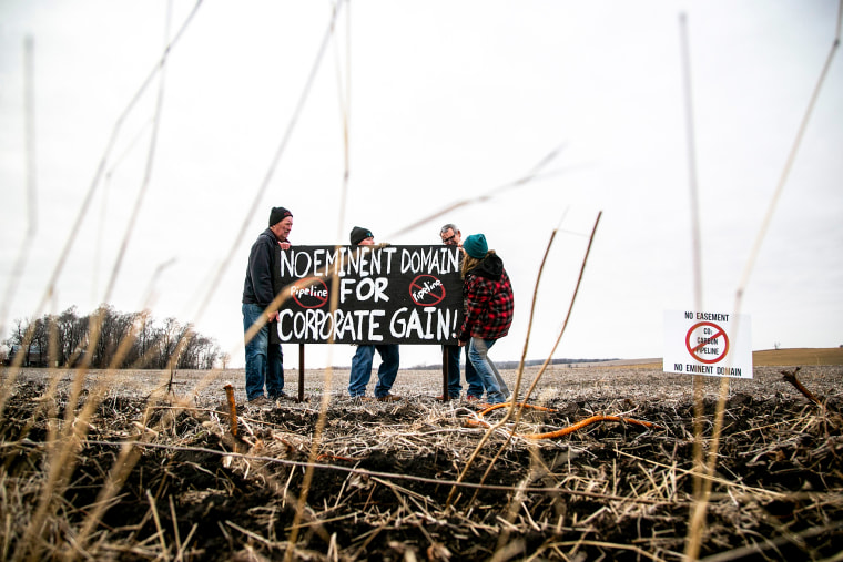 Protesters put up a sign reading "No eminent domain for corporate gain!" in opposition to a carbon capture and sequestration pipeline on Dec. 14, 2021, in Linn County, Iowa.