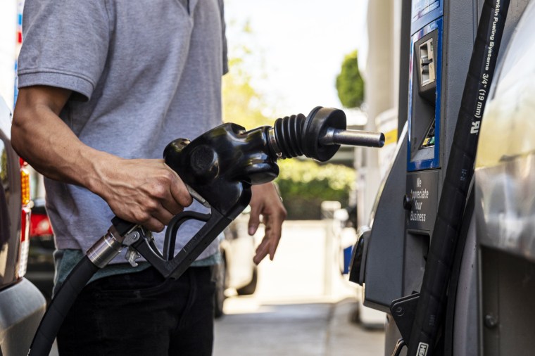 A driver returns a fuel nozzle to a gas pump