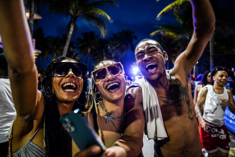 Revelers dance on Ocean Drive in Miami Beach, Fla., on March 15, 2022.