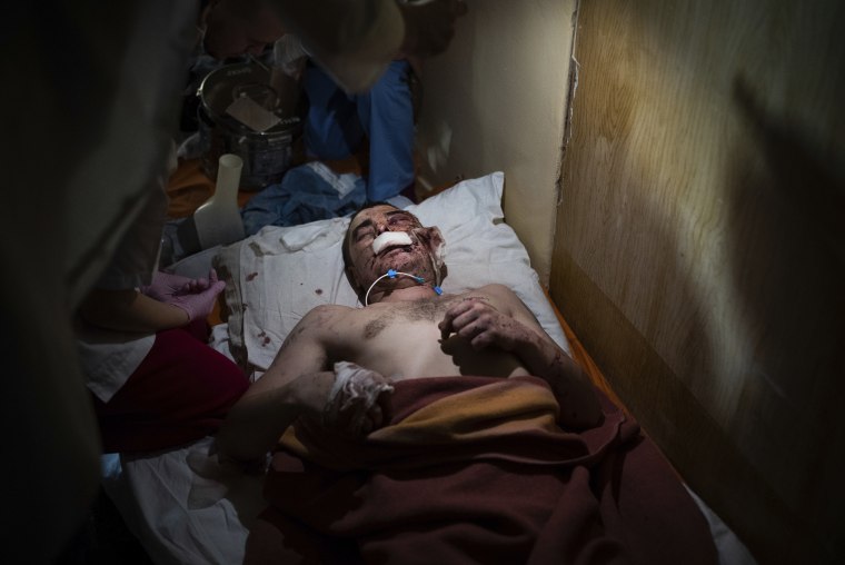 Medical workers treat a man wounded by shelling.