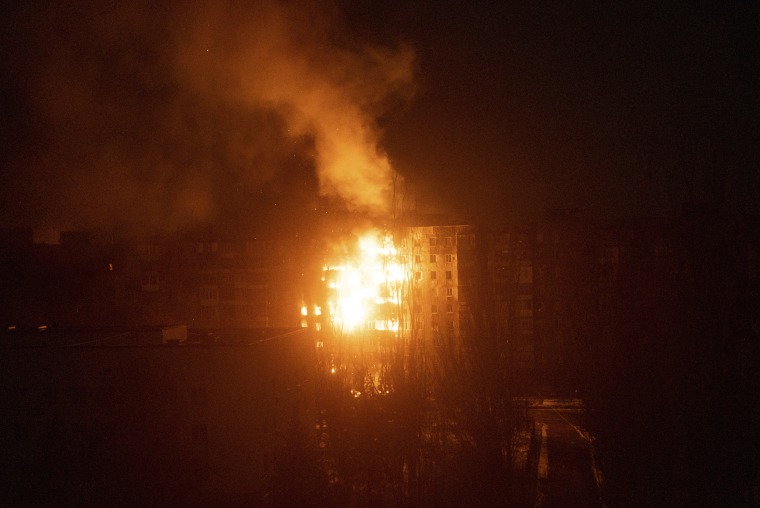 A fire burns at an apartment building after it was hit by shelling. 