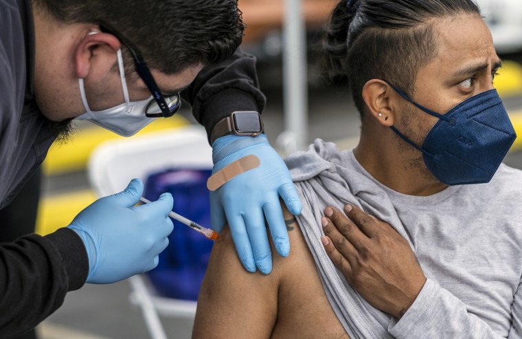 A healthcare professional gives a man a Covid-19 vaccination at the historic First African Methodist Episcopal Church (FAME) on Jan. 29, 2022 in Los Angeles.