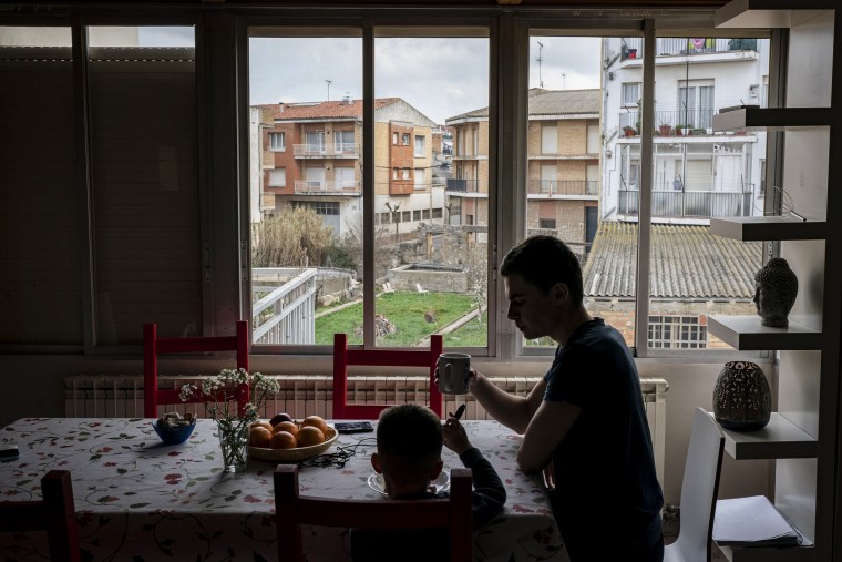 Maxym Batrak, 5 ans, de Brovary et Max Slobodianiuk, 17 ans, de Dnipro, déjeunent dans une maison du village de Guissona, Lleida, Espagne, le 22 mars 2022.