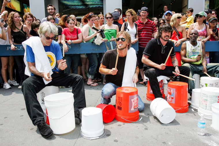 Stuart Copeland, formerly of The Police, left, Taylor Hawkins and Dave Grohl of the Foo Fighters perform on a drum circle during MTV2's "24 hours of fu" On June 11, 2005. in New York.