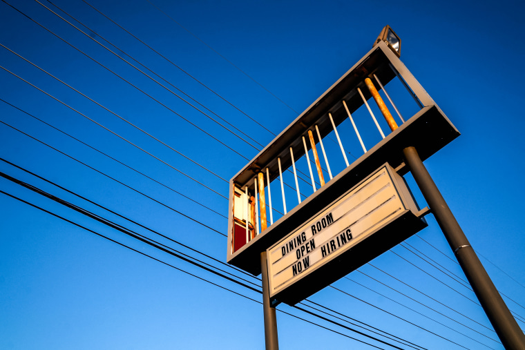 A Now Hiring sign is displayed in front of a restaurant in Rehoboth Beach, Del., on March 19, 2022.