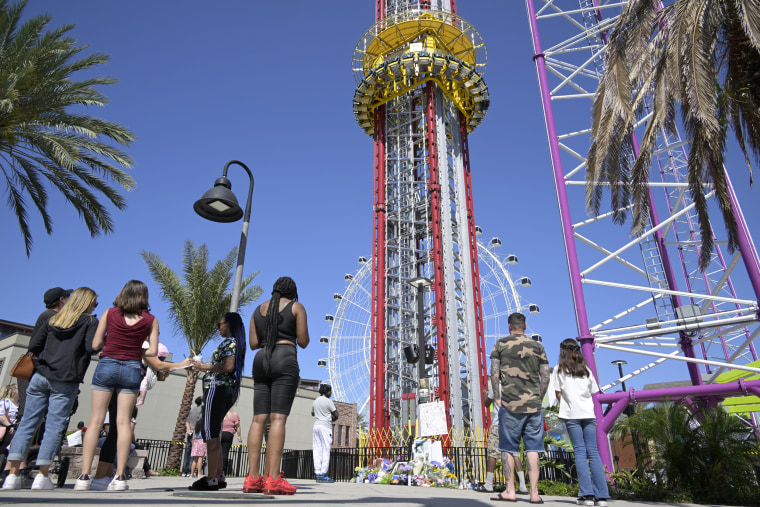 People visit a makeshift memorial to Tire Sampson outside of the Orlando Free Fall ride at ICON Park on March 27, 2022, in Orlando, Fla.