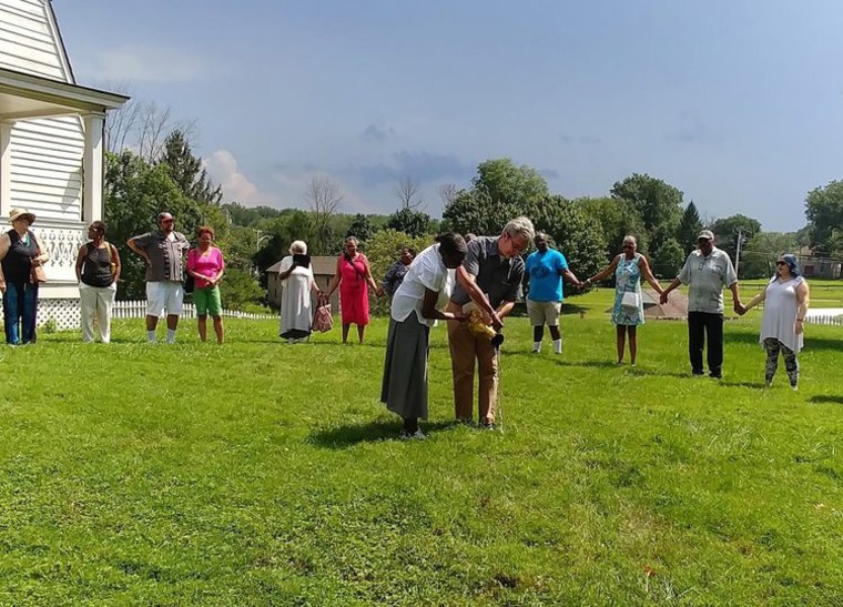 Natalie Conway and Steve Howard participate in a “libation ceremony” at Hampton Plantation. Conway's great-great-grandmother was enslaved at the plantation, and Howard is a descendant of the plantation’s owners, the Ridgely Howards. 