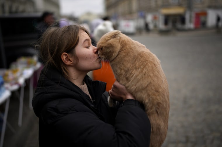 Julia Lazarets juega con su gato Gabriel, después de huir de Ucrania y llegar a la estación de trenes de Przemysl, Polonia, el martes 8 de marzo de 2022.