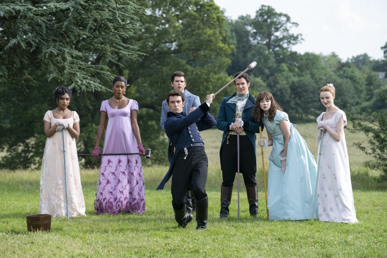 (L to R) Charithra Chandran as Edwina Sharma, Simone Ashley as Kate Sharma, Luke Newton as Colin Bridgerton, Luke Thompson as Benedict Bridgerton, Jonathan Bailey as Anthony Bridgerton, Claudia Jessie as Eloise Bridgerton and Phoebe Dyvenor as Daphne Basset in "Bridgerton" season two.