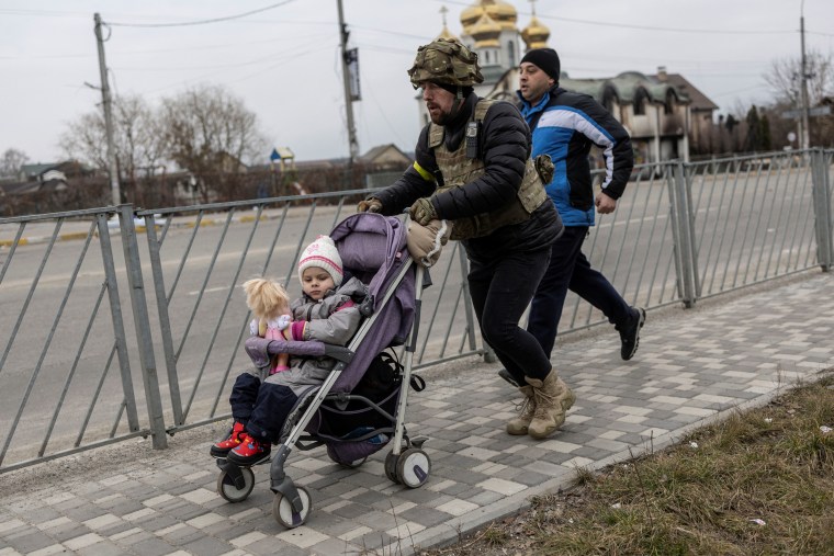 Un miembro del servicio de las fuerzas armadas ucranianas ayuda a evacuar a un niño de la ciudad de Irpin, Ucrania 7 de marzo de 2022.