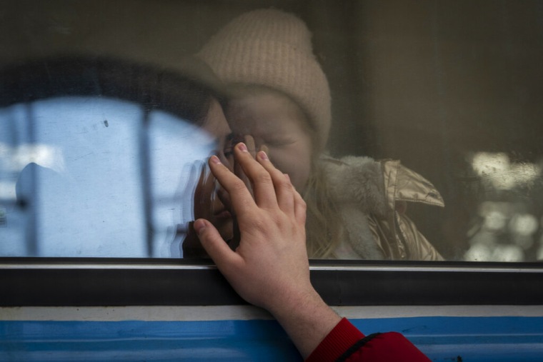 Ucranianos desplazados en un tren con destino a Polonia se despiden en Lviv, Ucrania occidental, el martes 22 de marzo de 2022.