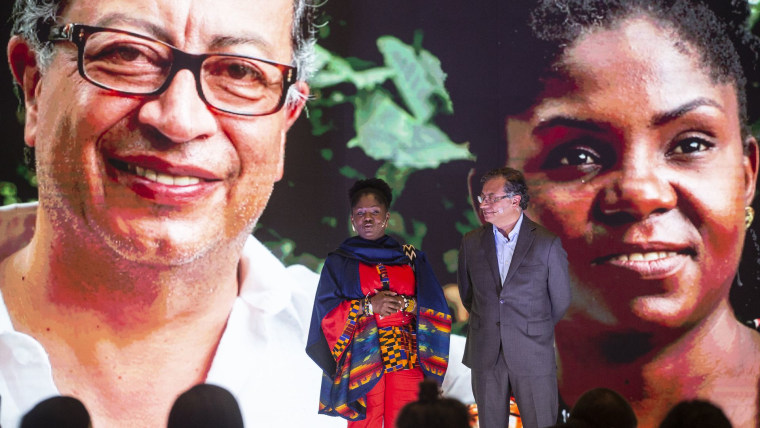 La afrocolombiana Francia Márquez habla junto al colombiano Gustavo Petro frente a una foto de ambos durante un acto de campaña