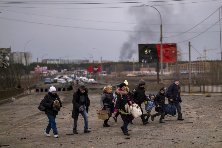 Un policía ayuda a evacuar a civiles en Ucrania en la ciudad de Irpin, a las afueras de Kiev