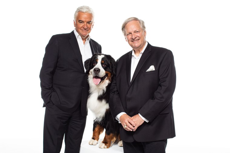John O'Hurley and David Frei smile with a Bernese mountain dog during a photo shoot for The National Dog Show on Aug.  19, 2019.