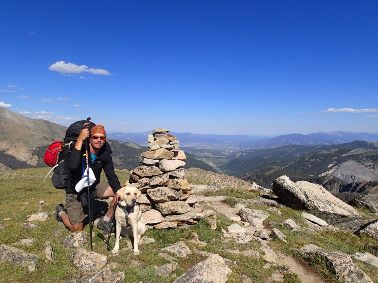 Trevor Thomas and his guide dog, Lulu, pause for a photo atop the Continental Divide in Colorado. 
