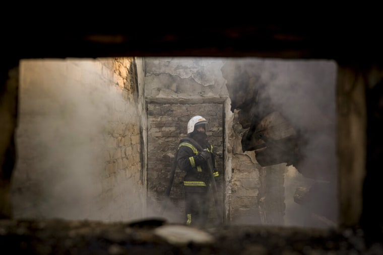 Un bombero ucraniano sostiene una manguera dentro de una casa destruida por un bombardeo en Kyiv, Ucrania, el miércoles 23 de marzo de 2022.