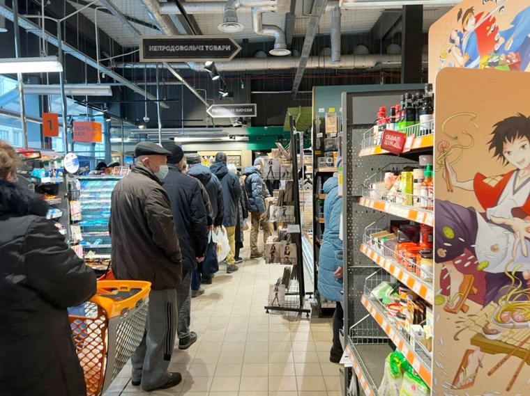 A picture of a long line at a neighborhood supermarket in Kyiv. Reports show Ukrainians still in Kyiv have limited access to food, water, and medicine. 