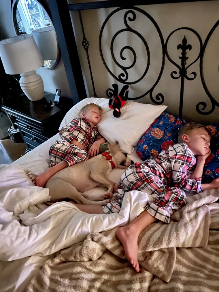 Roman Duncan and his brother Wyatt sleep alongside "the best dog you could ask for," foster pup Maggie.