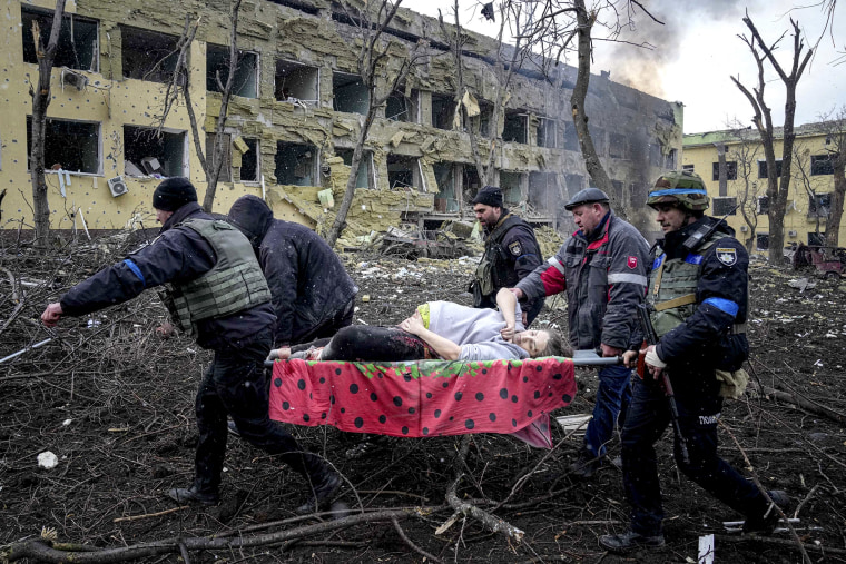 Empleados y voluntarios de emergencia ucranianos llevan a una mujer embarazada herida desde un hospital de maternidad que resultó dañado por los bombardeos en Mariupol, Ucrania, el 9 de marzo de 2022.