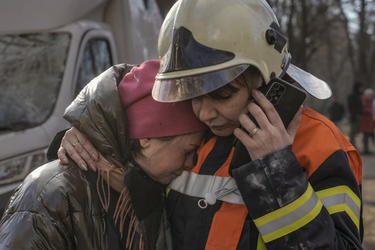 A firefighter comforts a woman