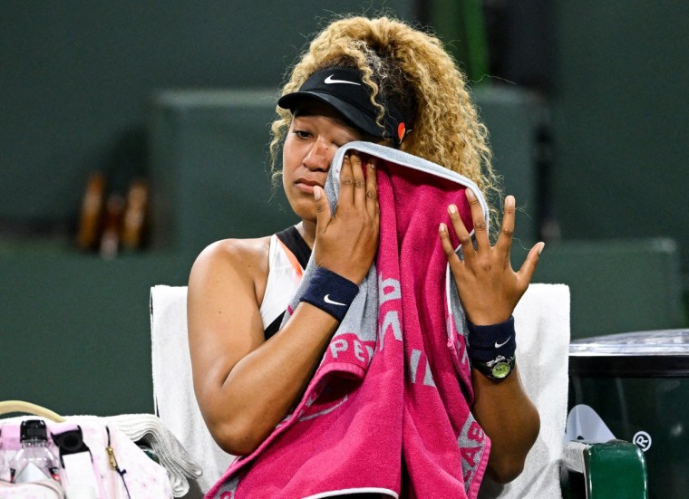 Naomi Osaka wipes her face as she talks to referee Claire Wood after a spectator disrupted play at the Indian Wells Tennis Garden on March 12, 2022.