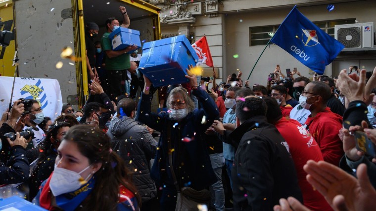 Un uruguayo carga una caja con firmas de votantes, en medio de festejos de sindicatos, para pedir convocar un referendo.