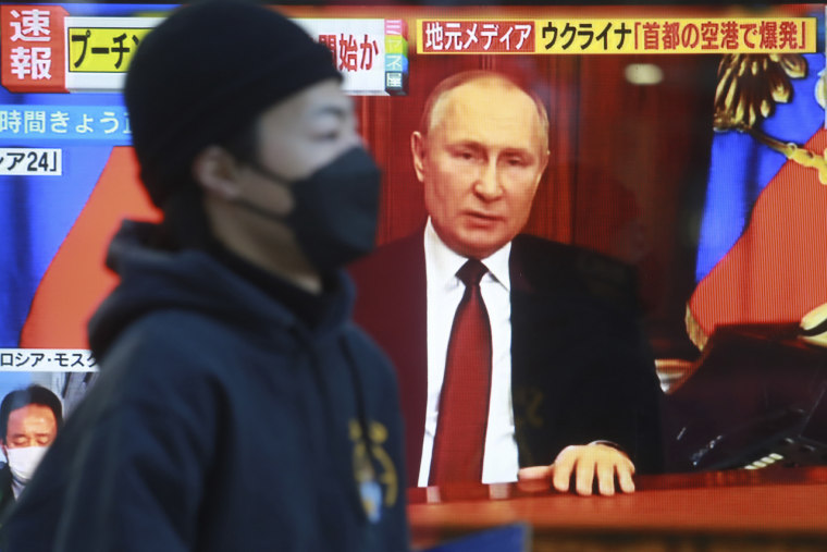 Un hombre camina en Tokio, Japón, frente a una pantalla de television que muestra al presidente ruso, Vladimir Putin. Rusia ha emprendido una campaña global de desinformación.