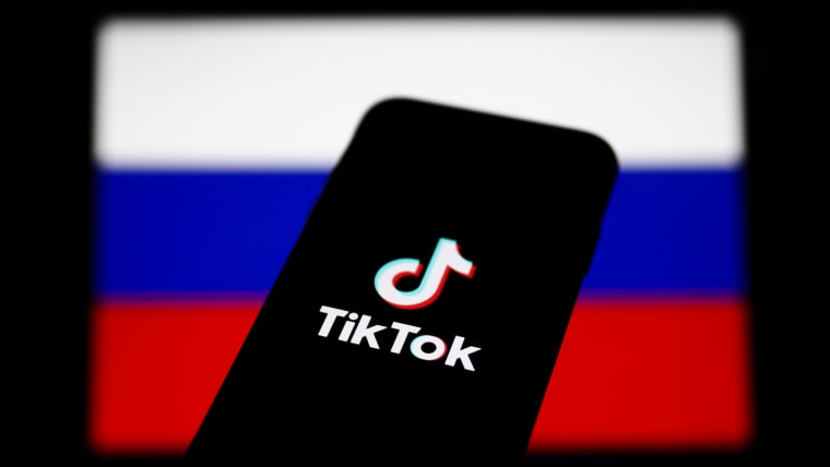 El logotipo de TikTok en la pantalla de un celular y la bandera rusa en el fondo, el 1 de marzo de 2022.
