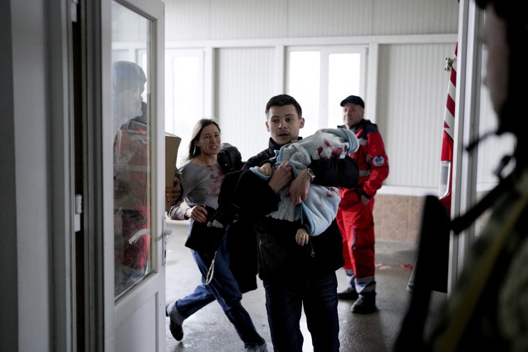 Marina Yatsko, a la izquierda, corre detrás de su novio Fedor con su hijo Kirill, de 18 meses, que murió en un bombardeo, cuando llegan a un hospital en Mariupol, Ucrania, el viernes 4 de marzo de 2022.