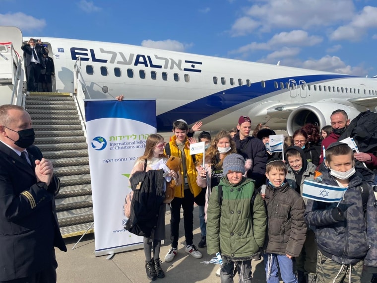 Some of the children pictured near the plane that delivered them safely to Israel, along with the caregivers and volunteers who made it possible.