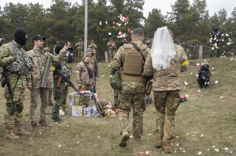 Ukrainian volunteers throw rose petals over newly-married members of the Ukrainian Territorial Defense Forces, Lesia Ivashchenko and Valerii Fylymonov, on their wedding ceremony on Sunday. 