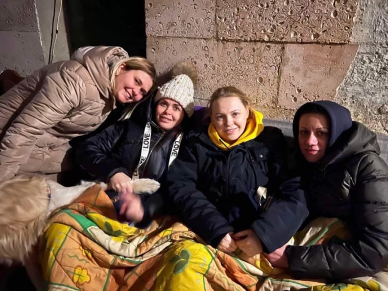 Olesia, pictured wearing a black jacket and the word "love" on her clothes, is shown huddling with other Ukrainian women in a bomb shelter as Russians bombed Kyiv. 