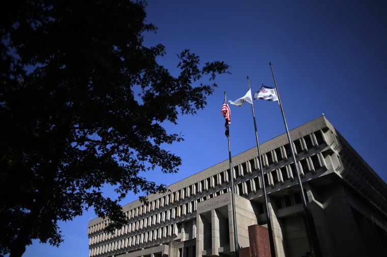 Flags fly above Boston City Hall on Nov. 11, 2021.