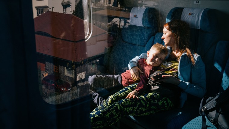  Nataliia Sukhar and her 5-year-old son, Gleb, rest on a train traveling from Poland to Berlin, Germany, after fleeing the violence in Ukraine.